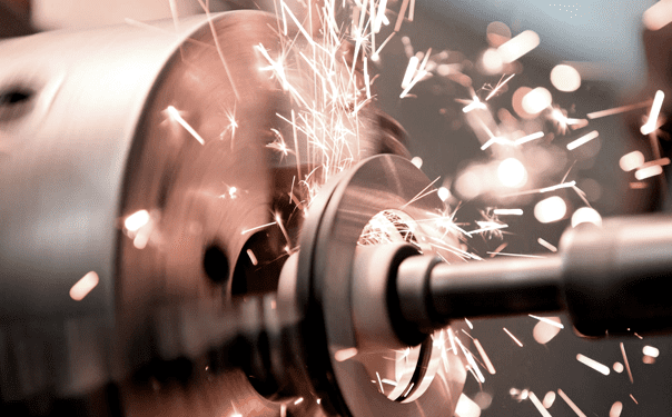 A close up of a metal grinder with sparks flying